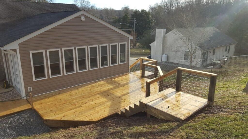 A house with a wooden deck and stairs in front of it.