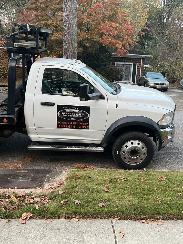 A white tow truck is parked on the side of the road.