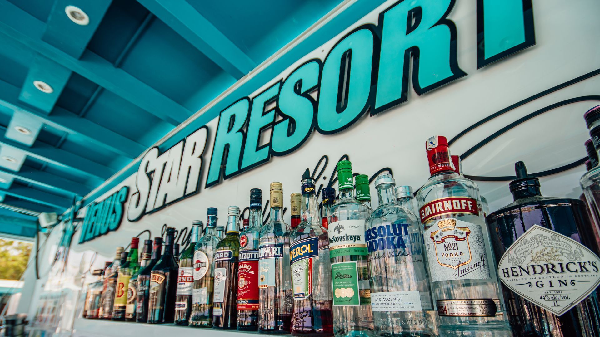 Bar Resor sign above a row of assorted liquor bottles on a shelf