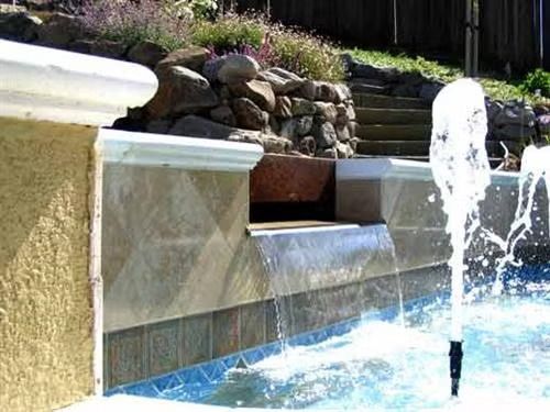 A sprinkler with a patch of green grass on top sprays water onto a lawn.