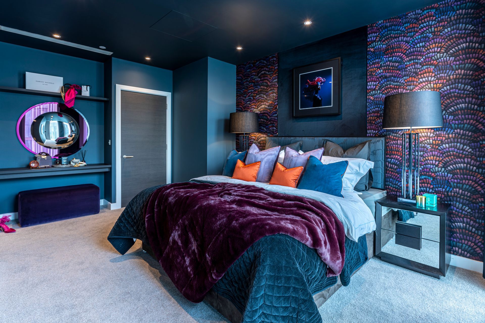 Luxurious bedroom with blue walls, plush bed, and patterned accent wall.