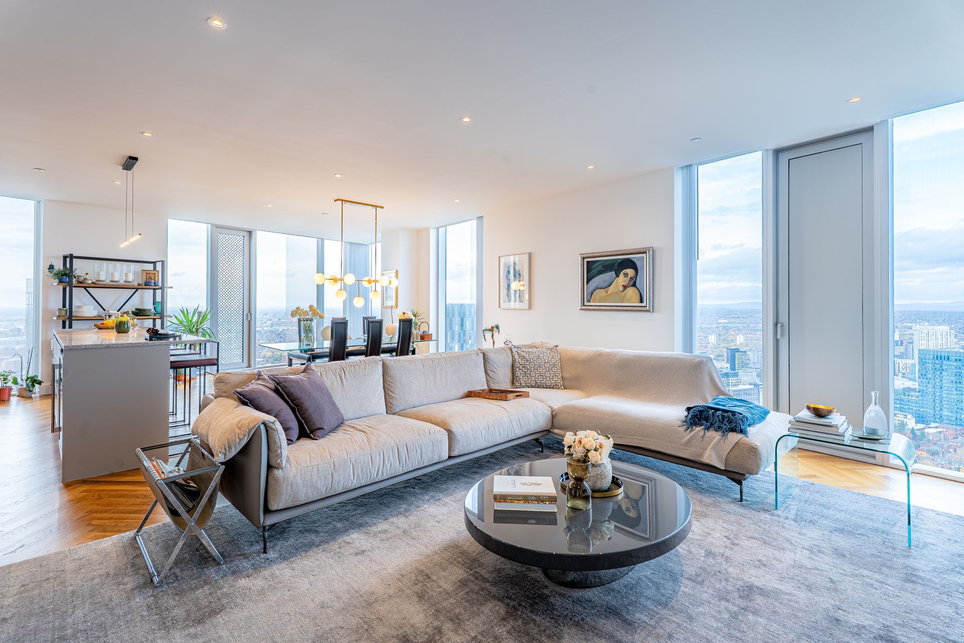 Modern living room with sectional sofa, coffee table, and city views.