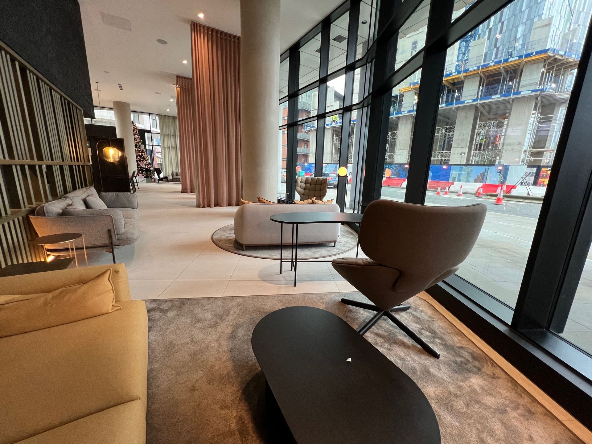 Lobby with seating, large windows, and a building under construction visible outside.