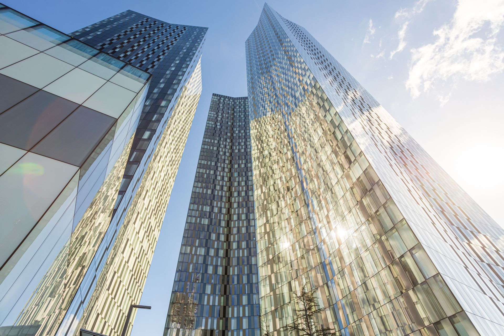 Skyscrapers with reflective glass facades against a bright blue sky.