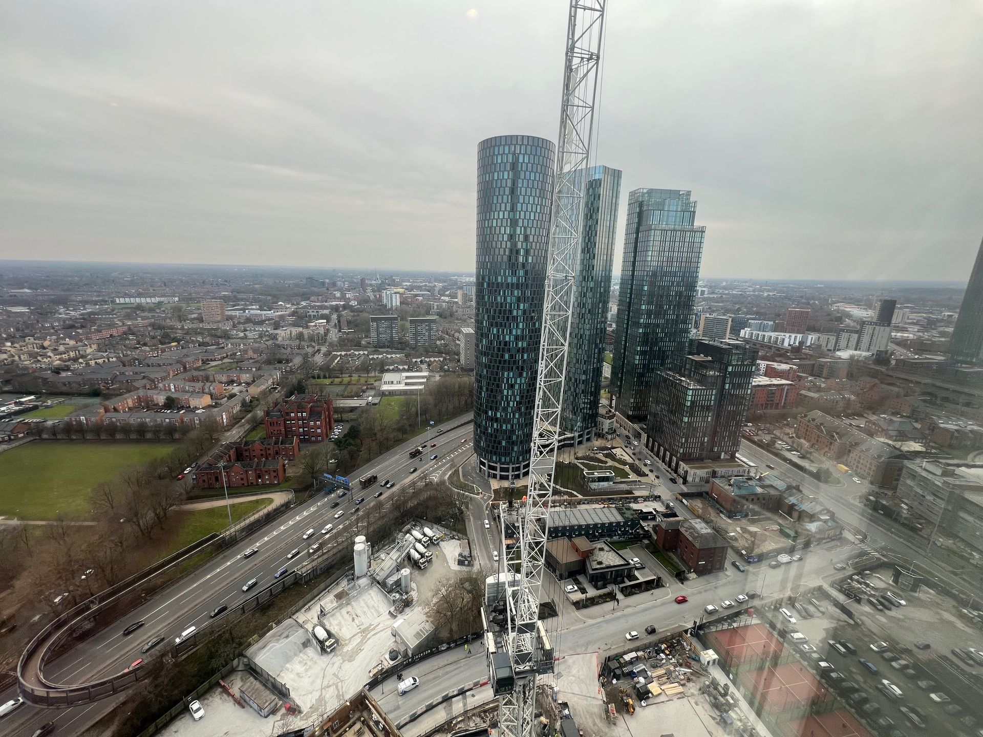 Aerial view of London skyline, tall skyscrapers, highway, construction crane.