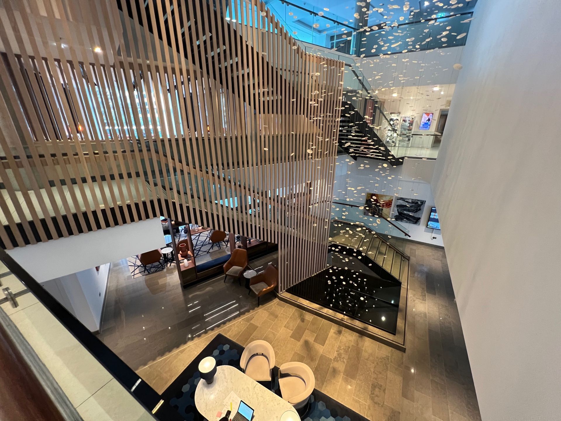 Modern interior with wooden slat walls, a multi-level open space, and seating areas.