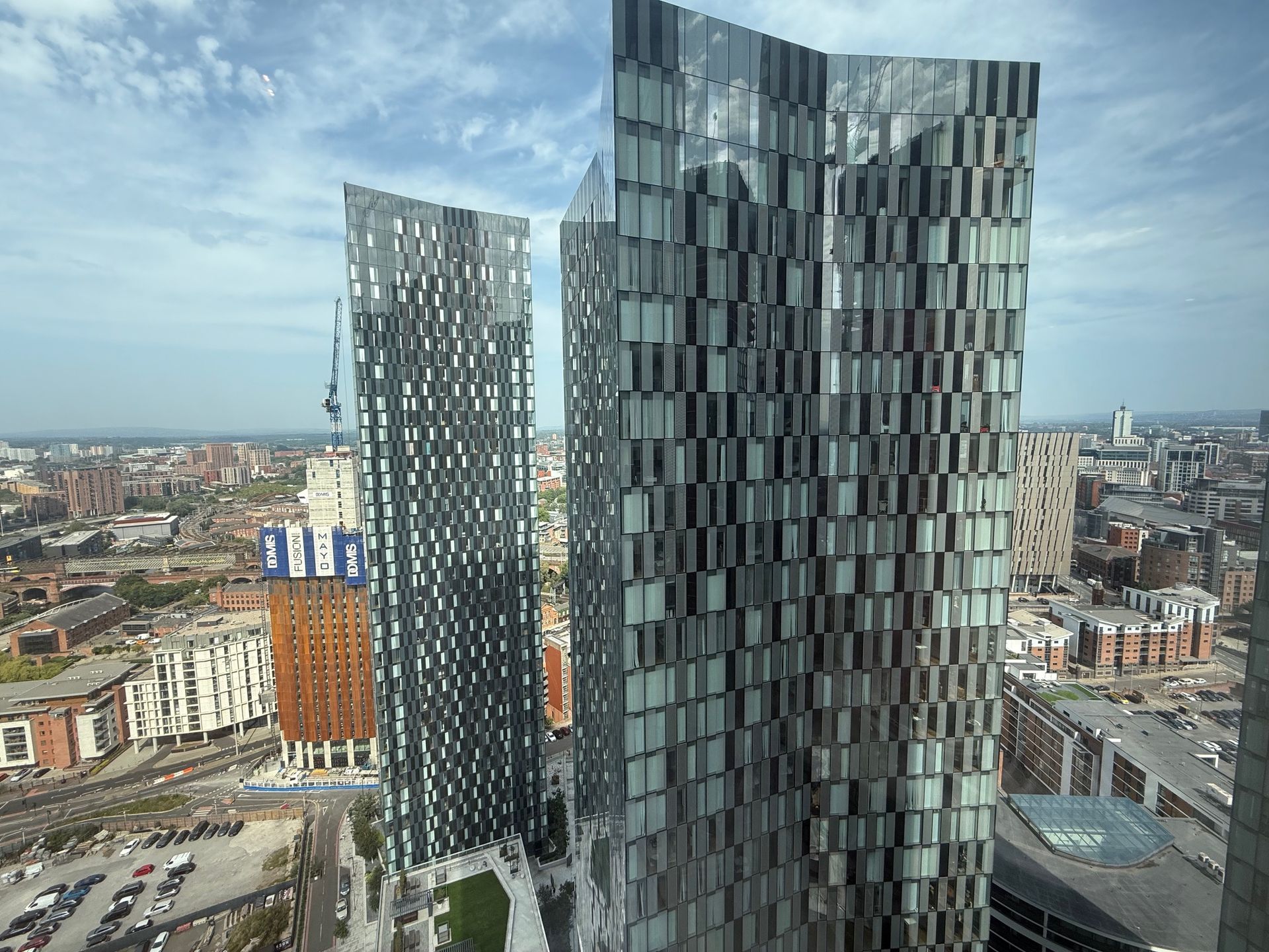 Two tall, modern skyscrapers with reflective glass facades dominate a cityscape.
