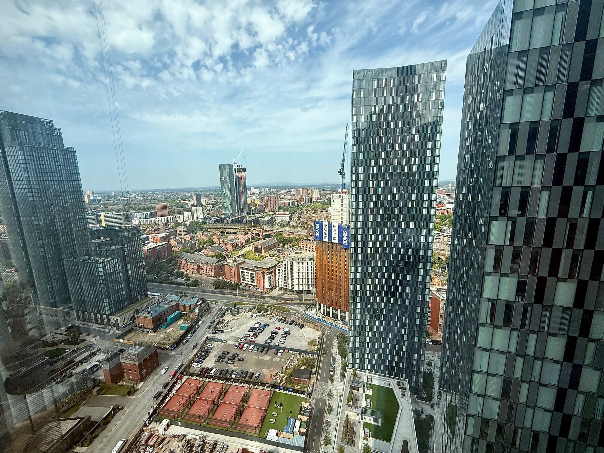 City skyline view with modern skyscrapers, blue sky, and cityscape in the distance.
