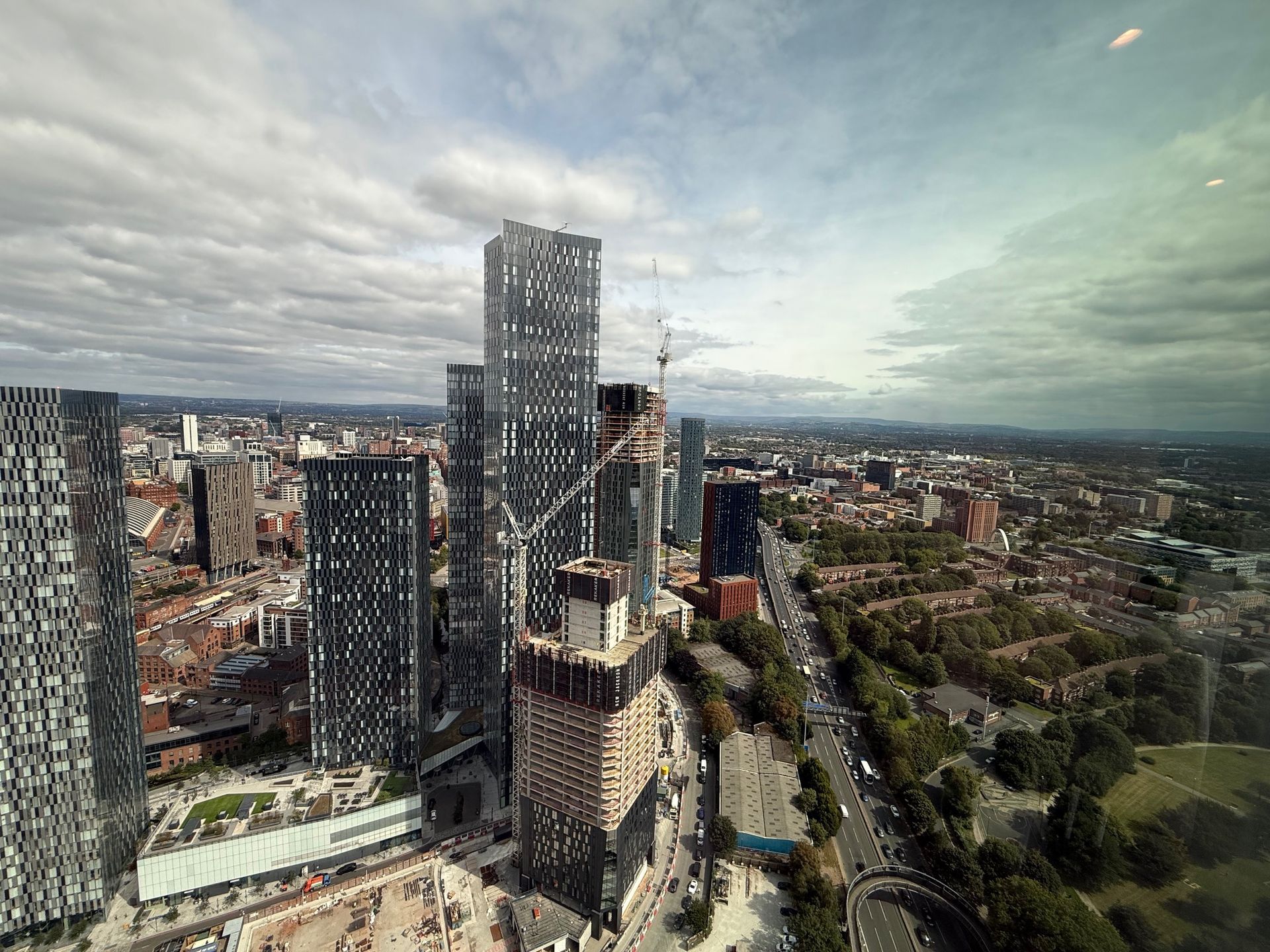 Cityscape view with tall buildings and cloudy sky.