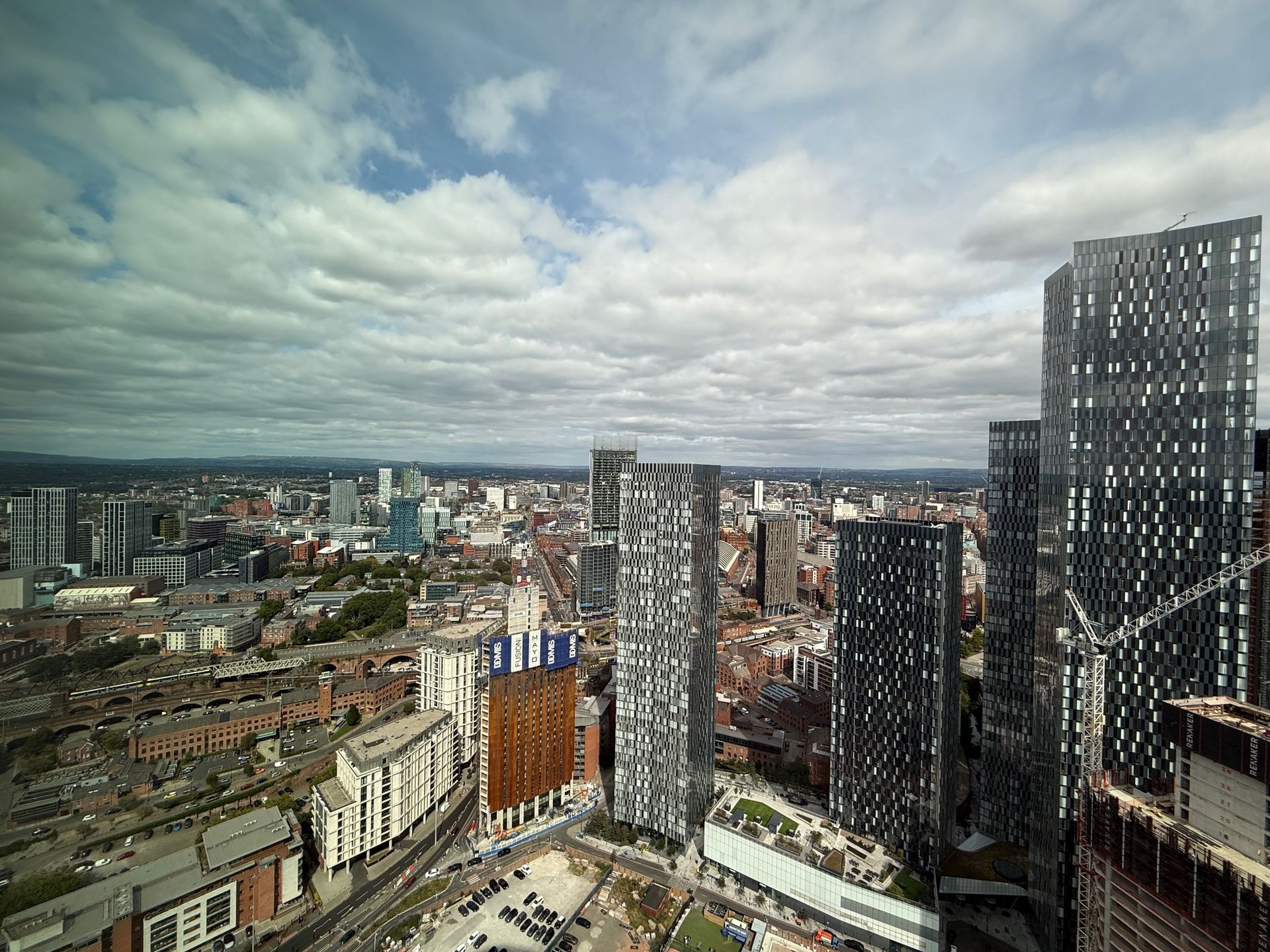 Cityscape with modern skyscrapers under a cloudy sky.