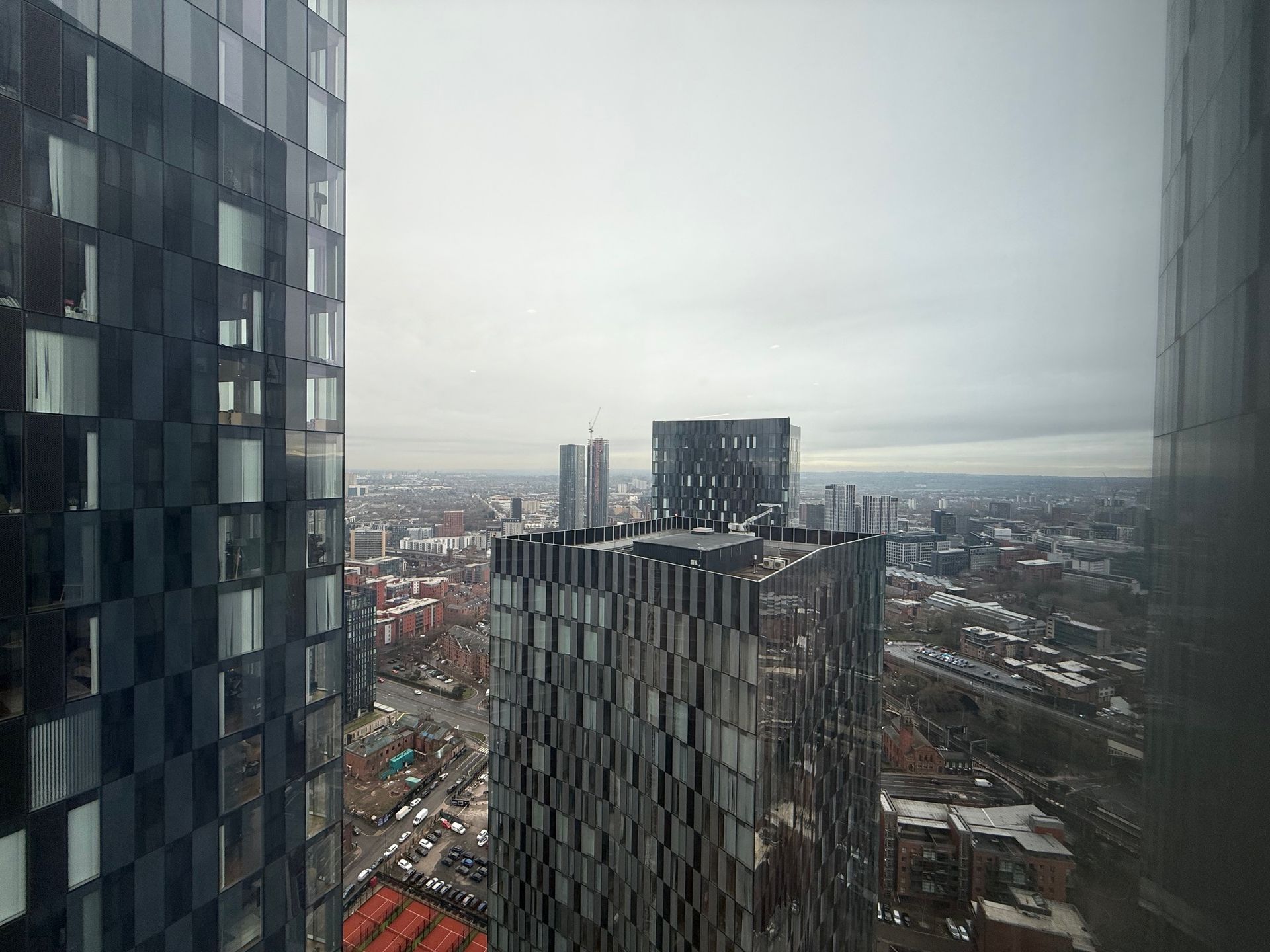City skyline view from tall buildings on a cloudy day.