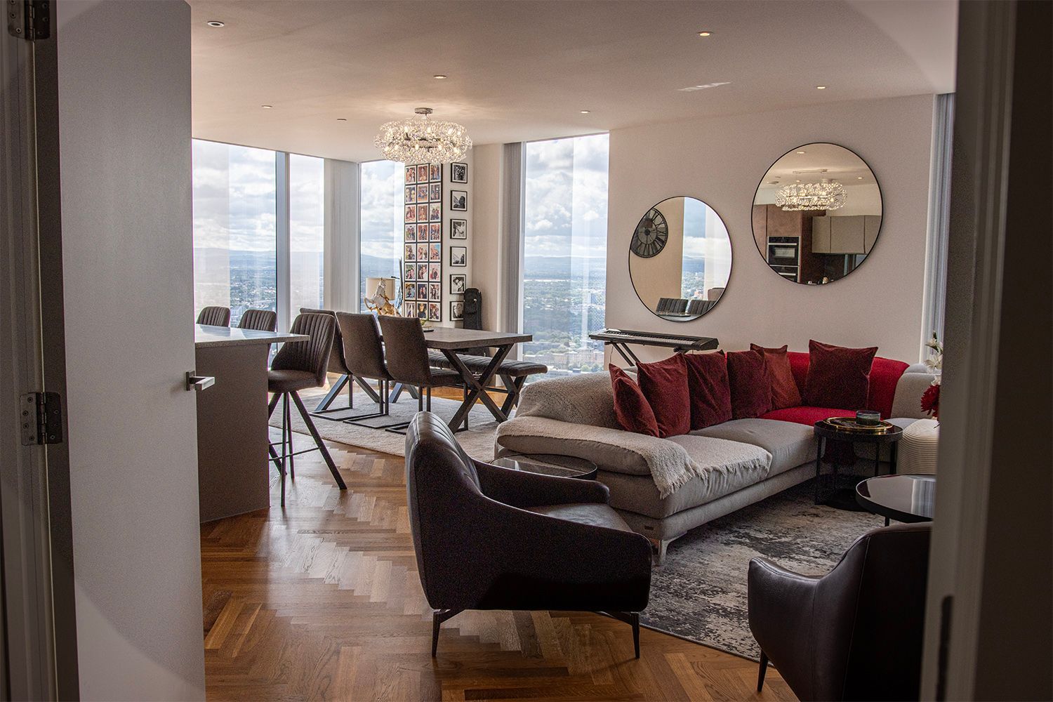 Luxurious modern living room with large windows, dining table, and sectional sofa.