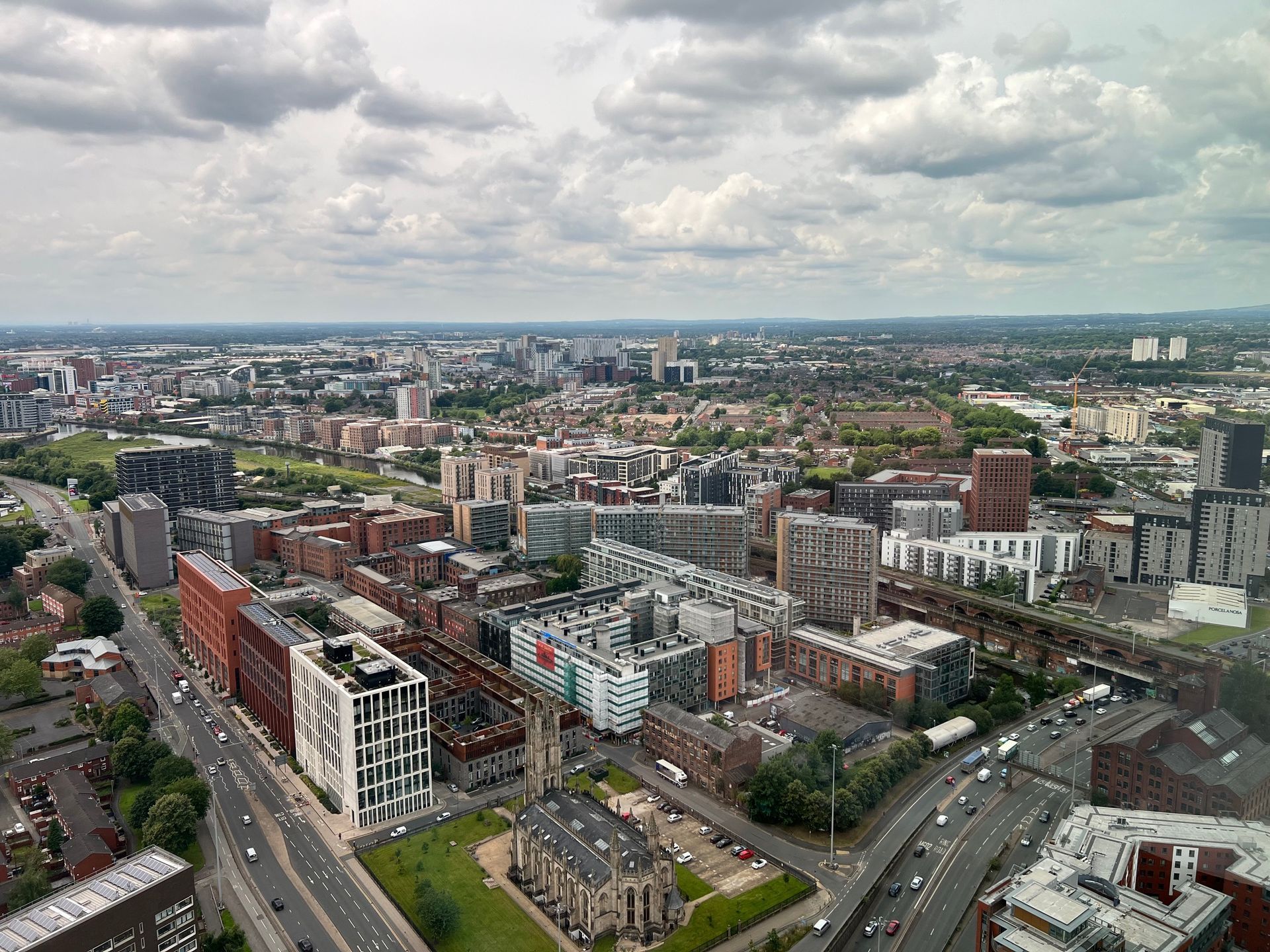 Cityscape with buildings and roads under a cloudy sky.