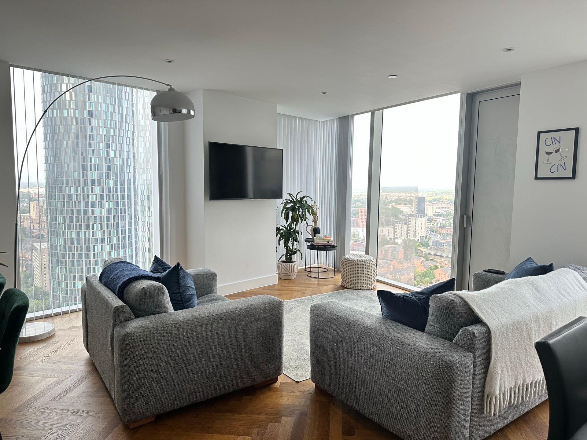 Living room with gray sofas, large windows, and a city view.