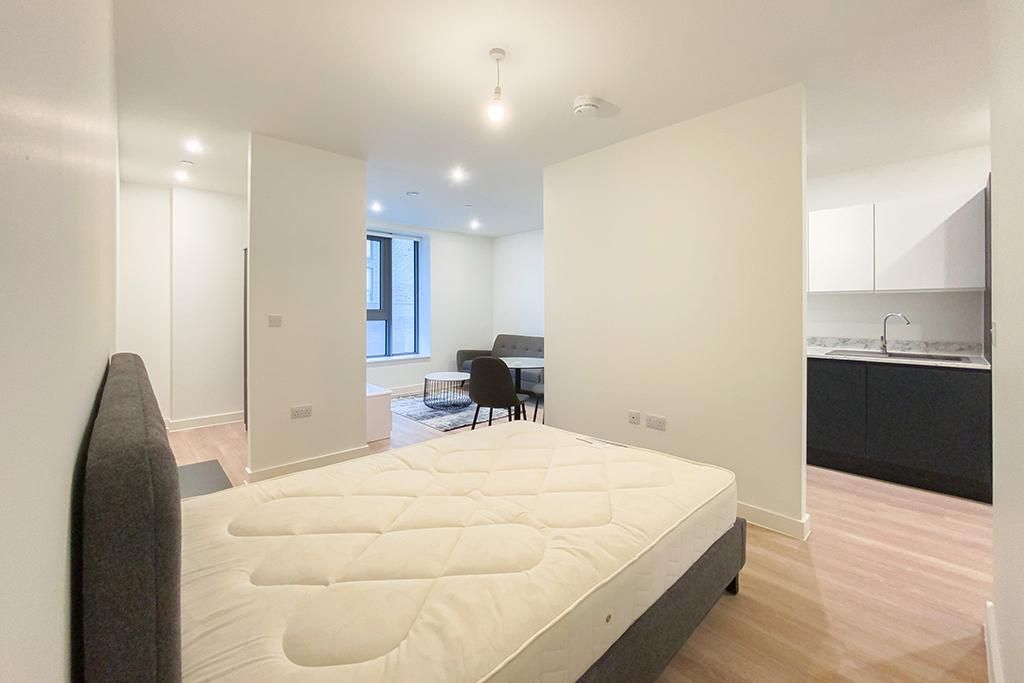 Bedroom with bed, and views of living room and kitchen.