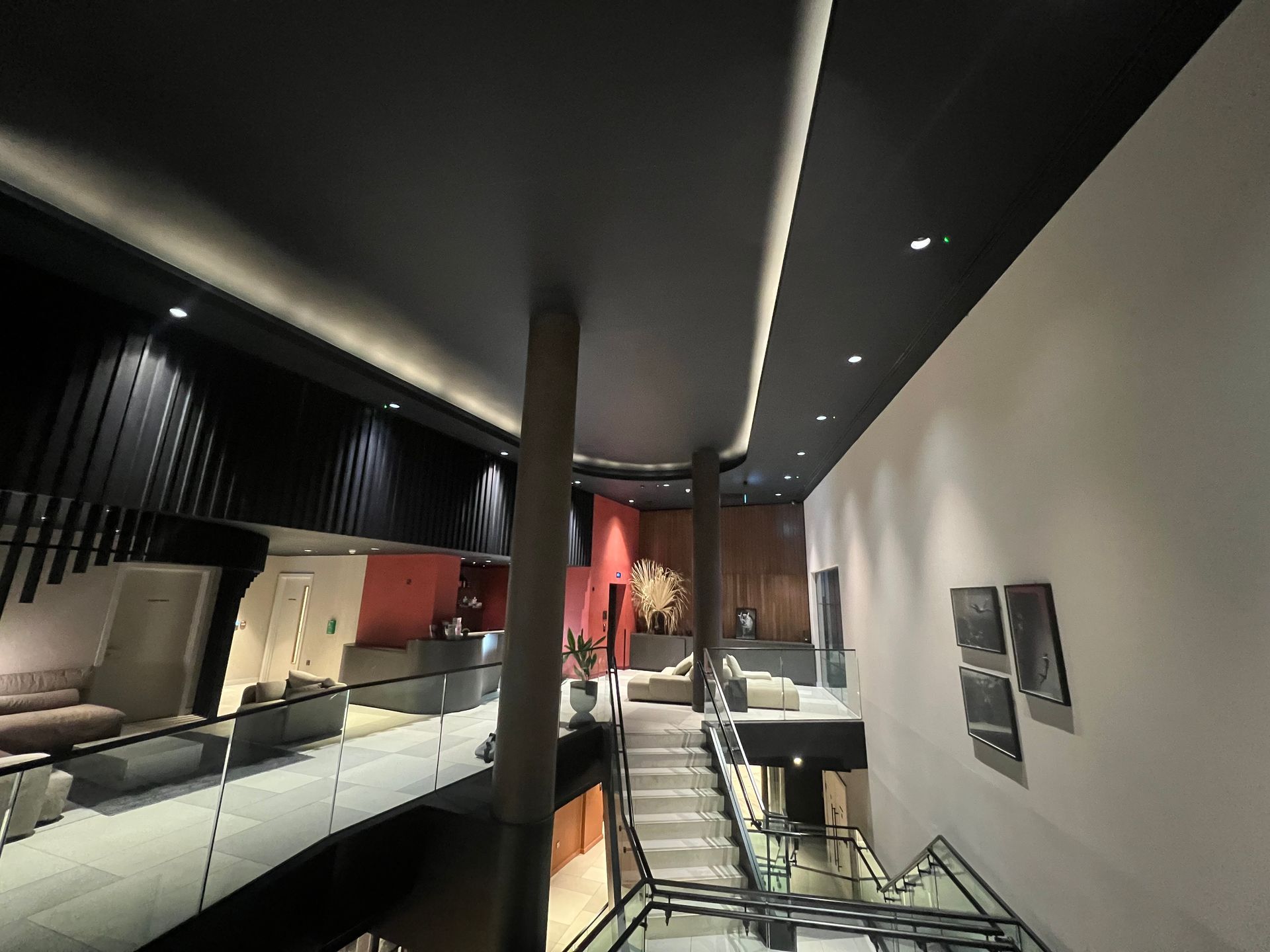 Modern interior: two-story building with dark ceiling, white walls, and a staircase.