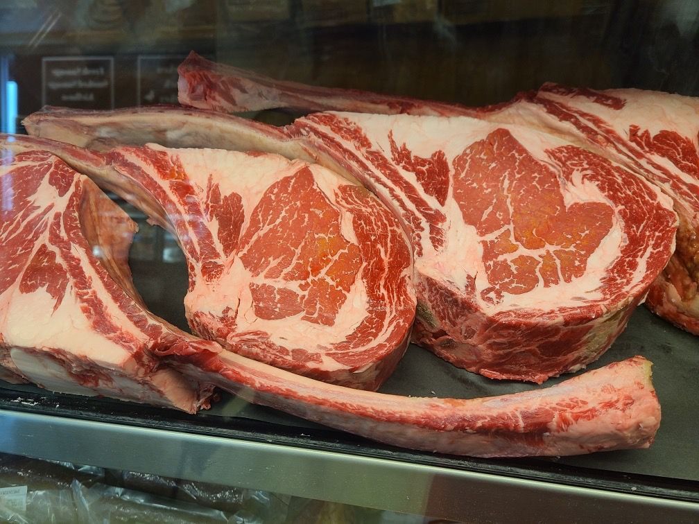 Raw marbled steaks displayed in a refrigerated meat case