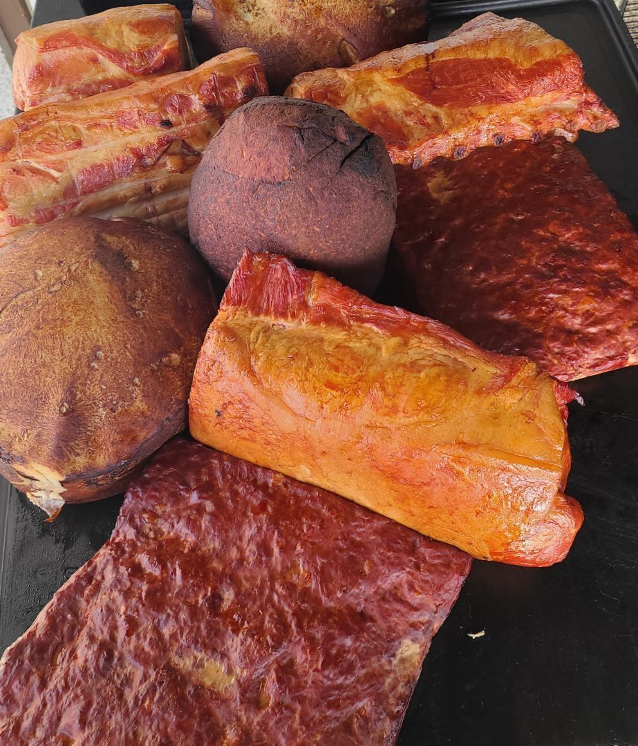 Assorted baked pastries and breads on a black tray, including golden and dark brown pieces.