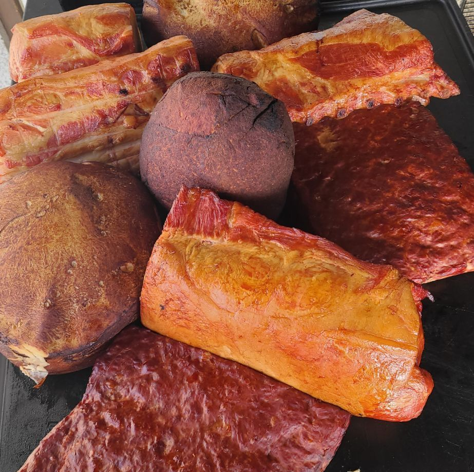 Assorted smoked fish pieces on a tray, with golden-brown and reddish skin.