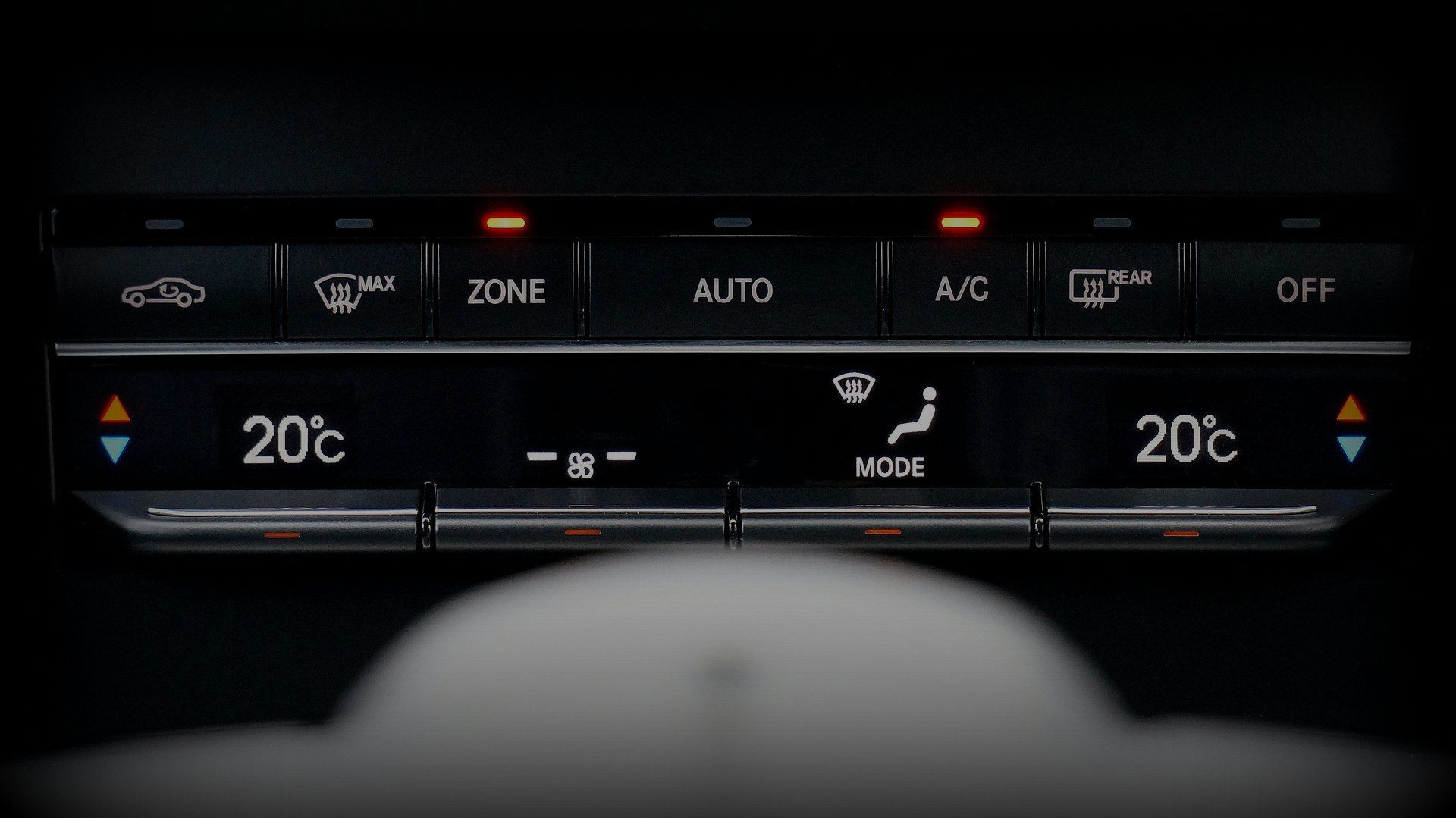 A close up of a car 's climate control with the temperature set at 20 degrees celsius