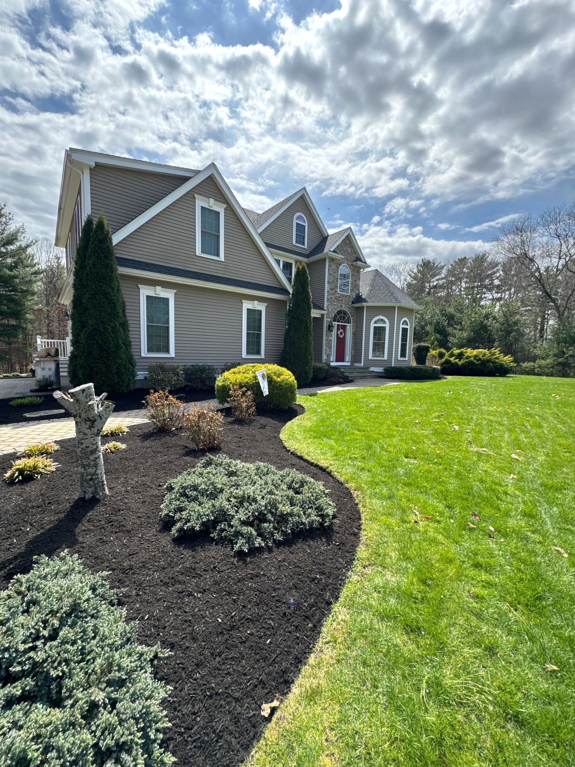 A large house with a lush green lawn in front of it.