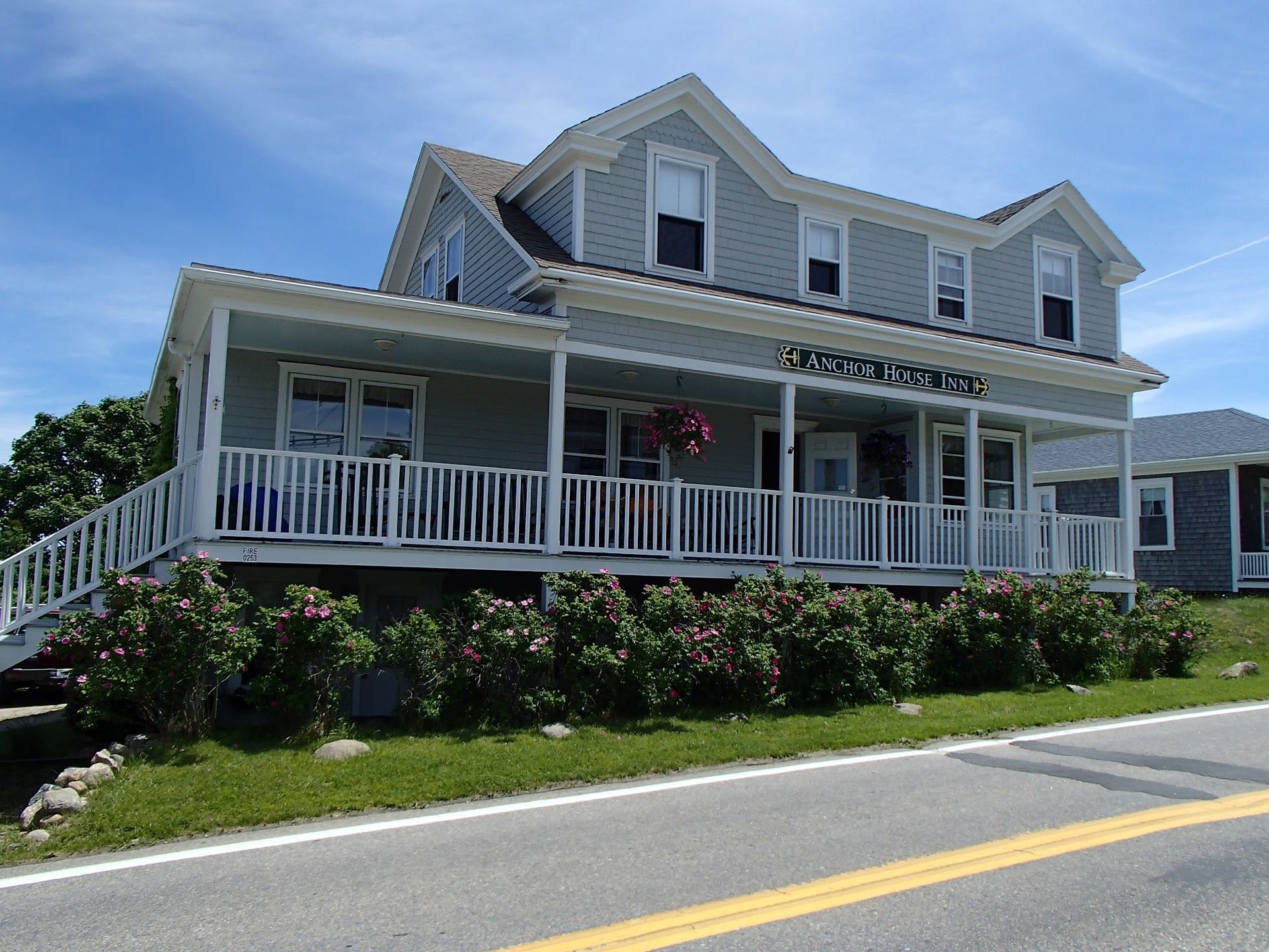 A large grey house with a white porch and stairs