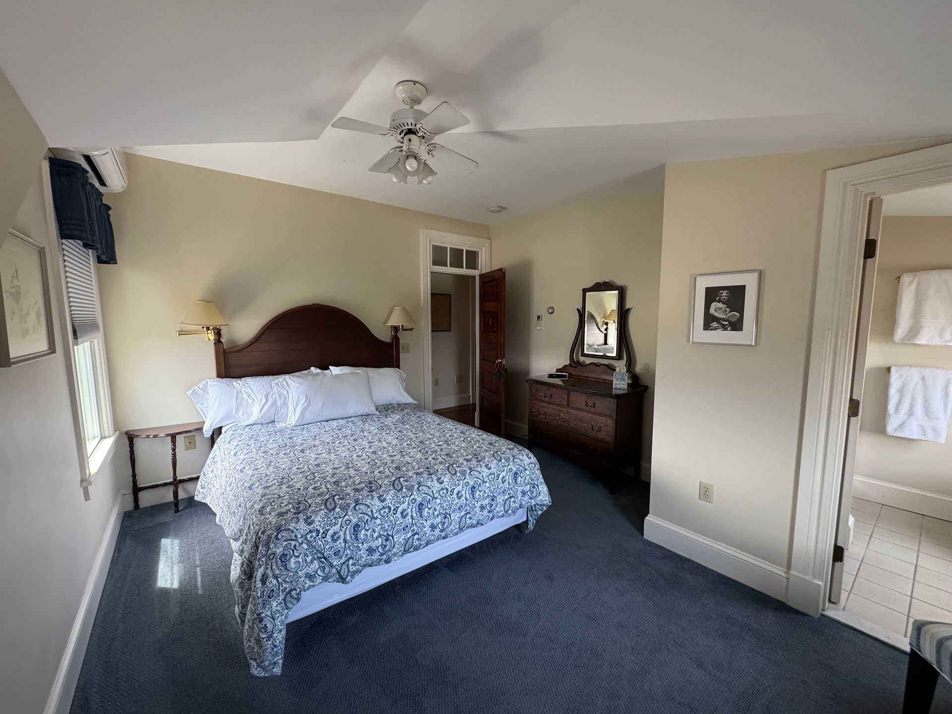 A bedroom with a king size bed and a ceiling fan