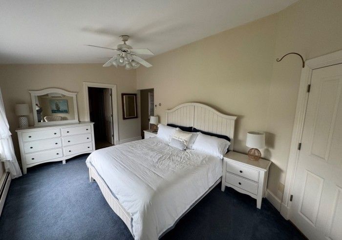 A bedroom with a king size bed and a dresser