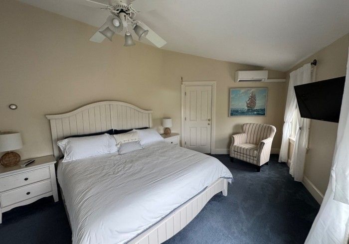 A bedroom with a king size bed and a chair