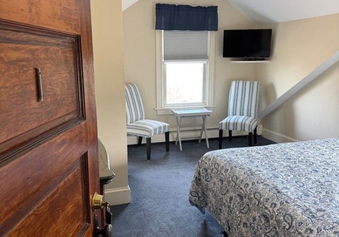 A bedroom with a bed , chairs and a television