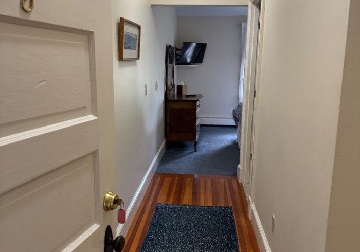 A hallway in a house with a rug on the floor