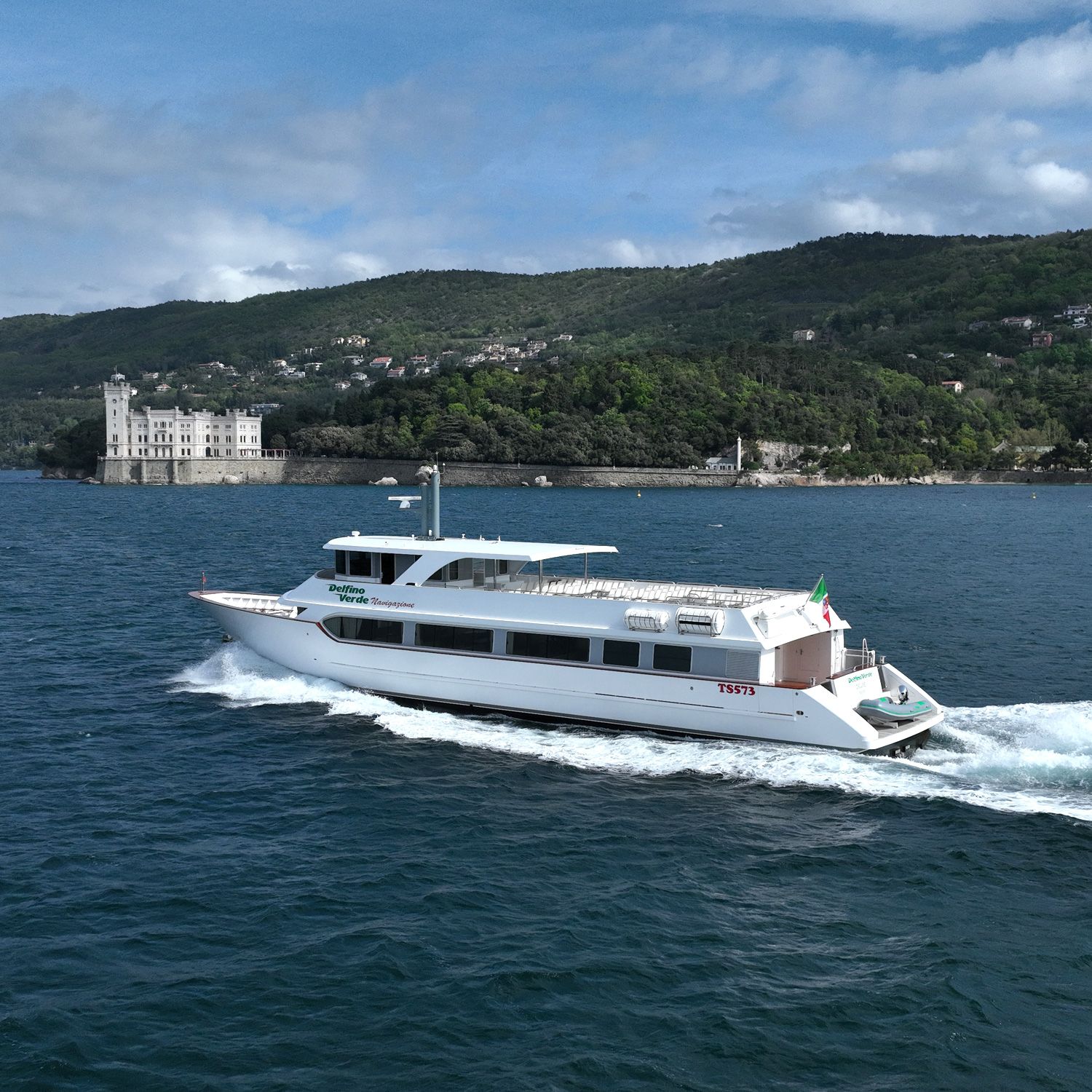 Foto di una motonave di Delfino Verde in mare vicino al Castello Miramare di Trieste