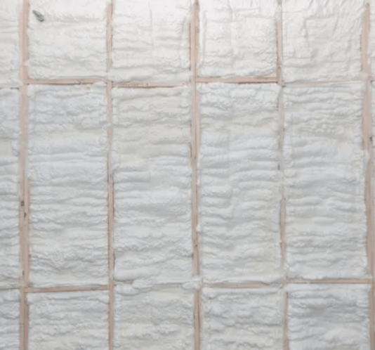 White fluffy insulation panels filling a grid formed by wooden beams.