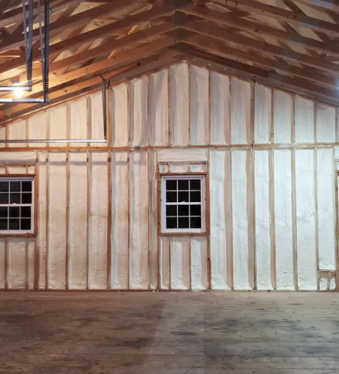 Interior view of a building's insulated walls and roof. Two windows are visible.