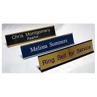 Three engraved desk nameplates: Chris Montgomery Realtor, Melissa Summers, and Ring Bell for Service