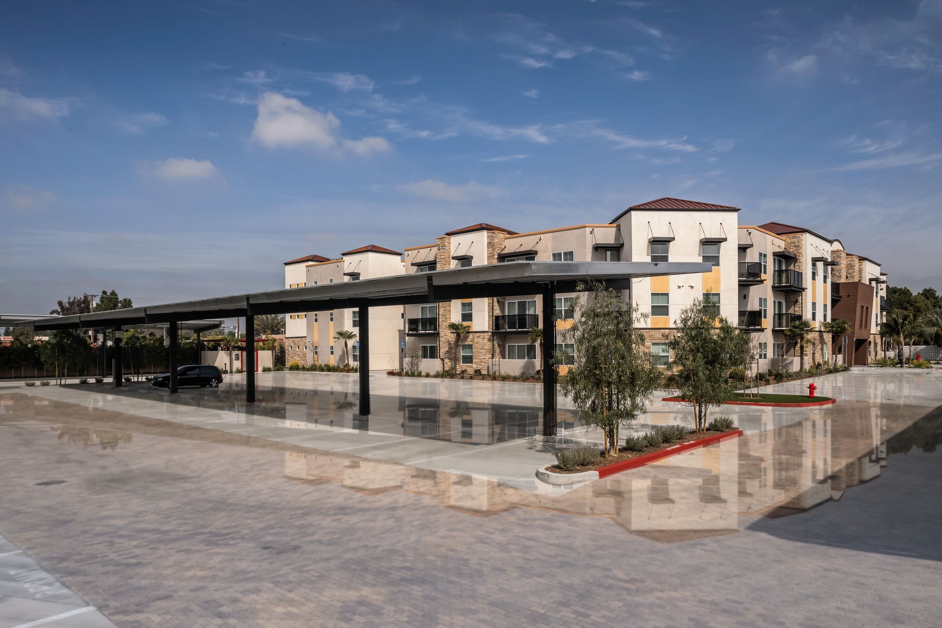 A large apartment building with a carport in front of it.