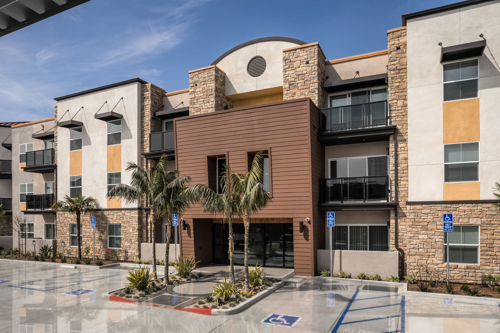 A large apartment building with a handicapped parking spot in front of it