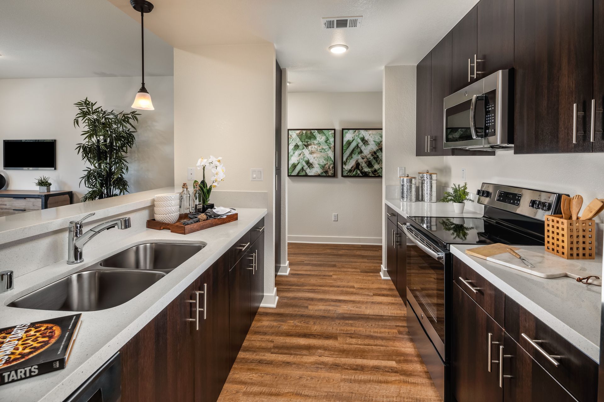 A kitchen with two sinks , a stove , and a microwave.