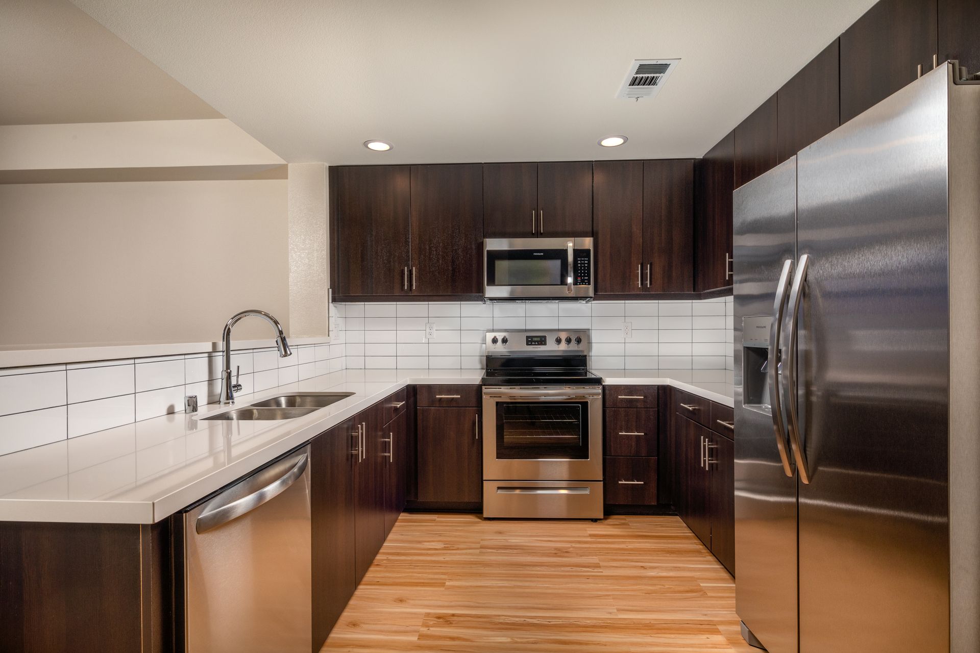 A kitchen with stainless steel appliances and wooden cabinets