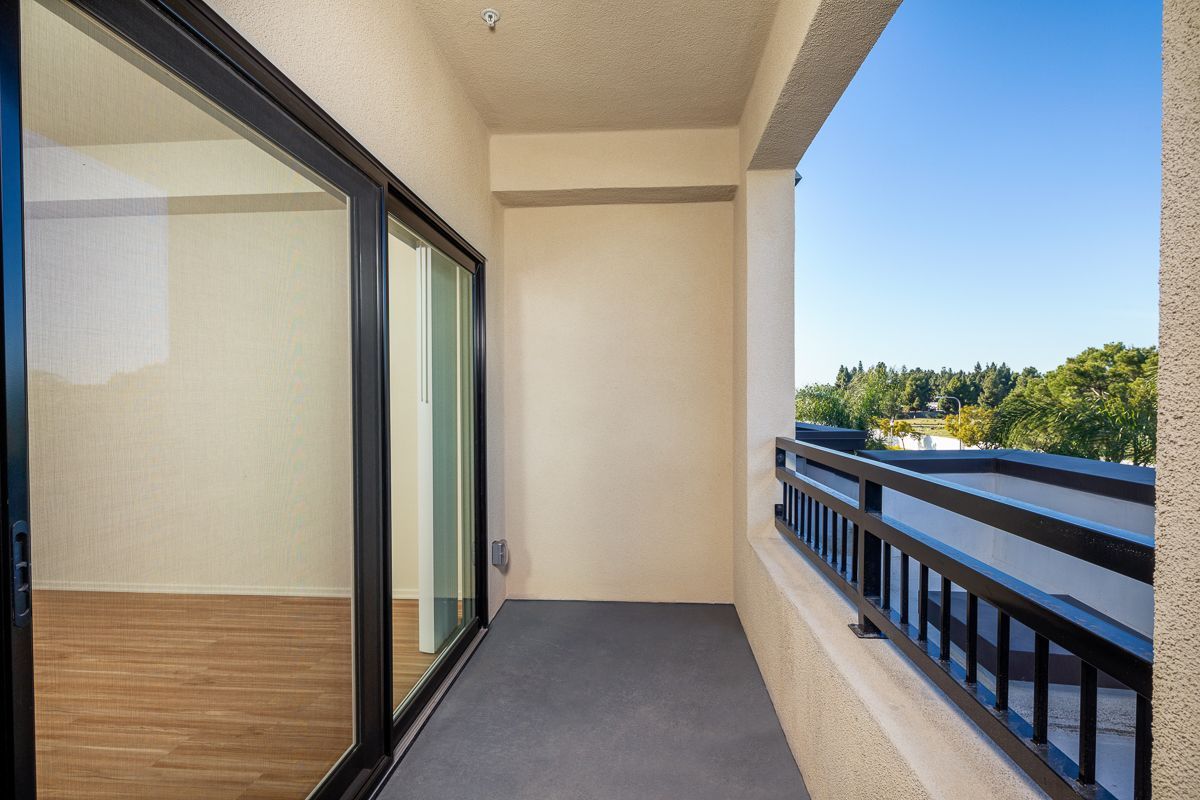 An empty balcony with sliding glass doors and a railing
