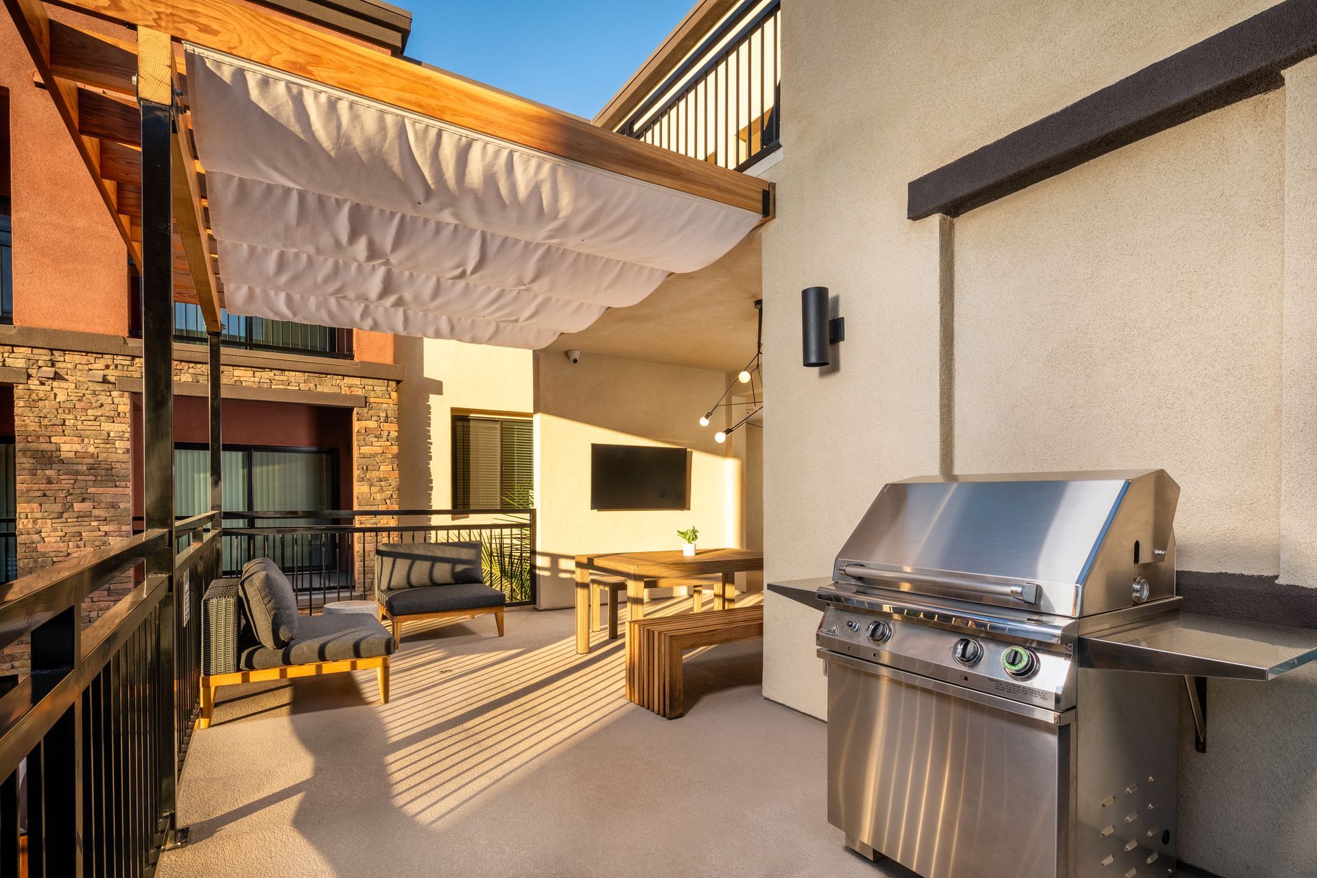 A patio with a grill and a canopy over it.