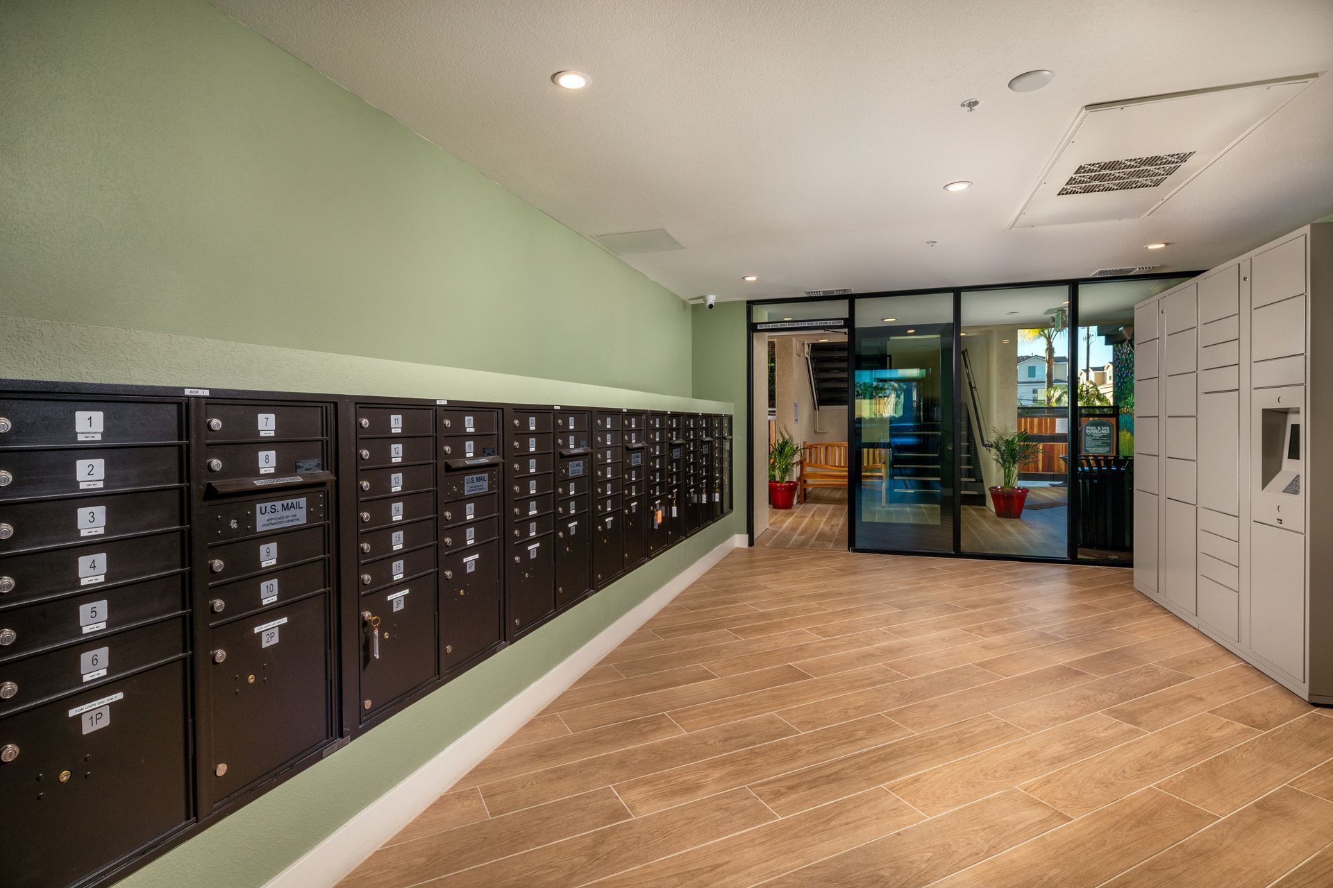 A row of mailboxes in a building with a wooden floor.