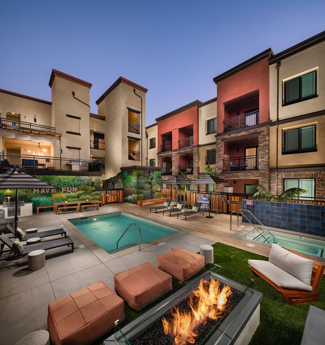 A large building with a pool and a fire pit in front of it