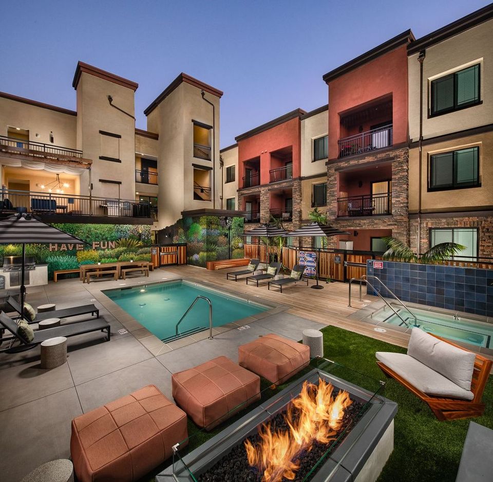 A swimming pool with a fire pit in the middle of it