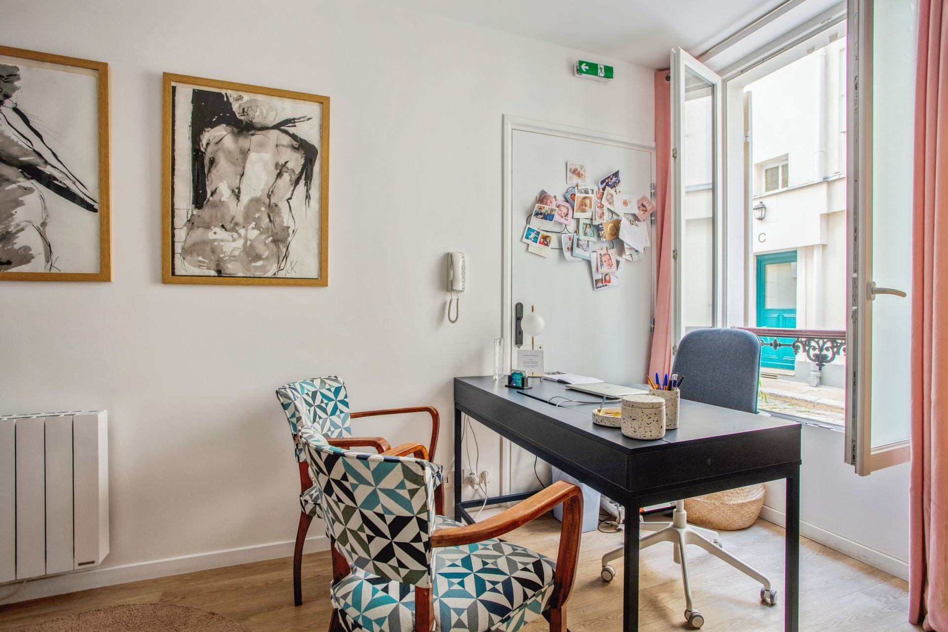 Un bureau avec un bureau, une chaise à roulettes, deux fauteuils à motifs
