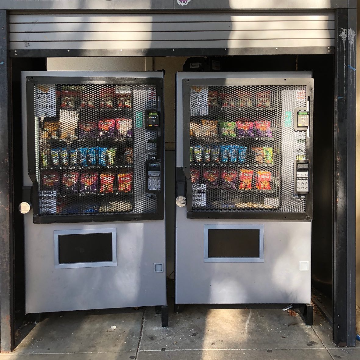 Person in plaid shirt using a vending machine's touchscreen, selecting a snack.