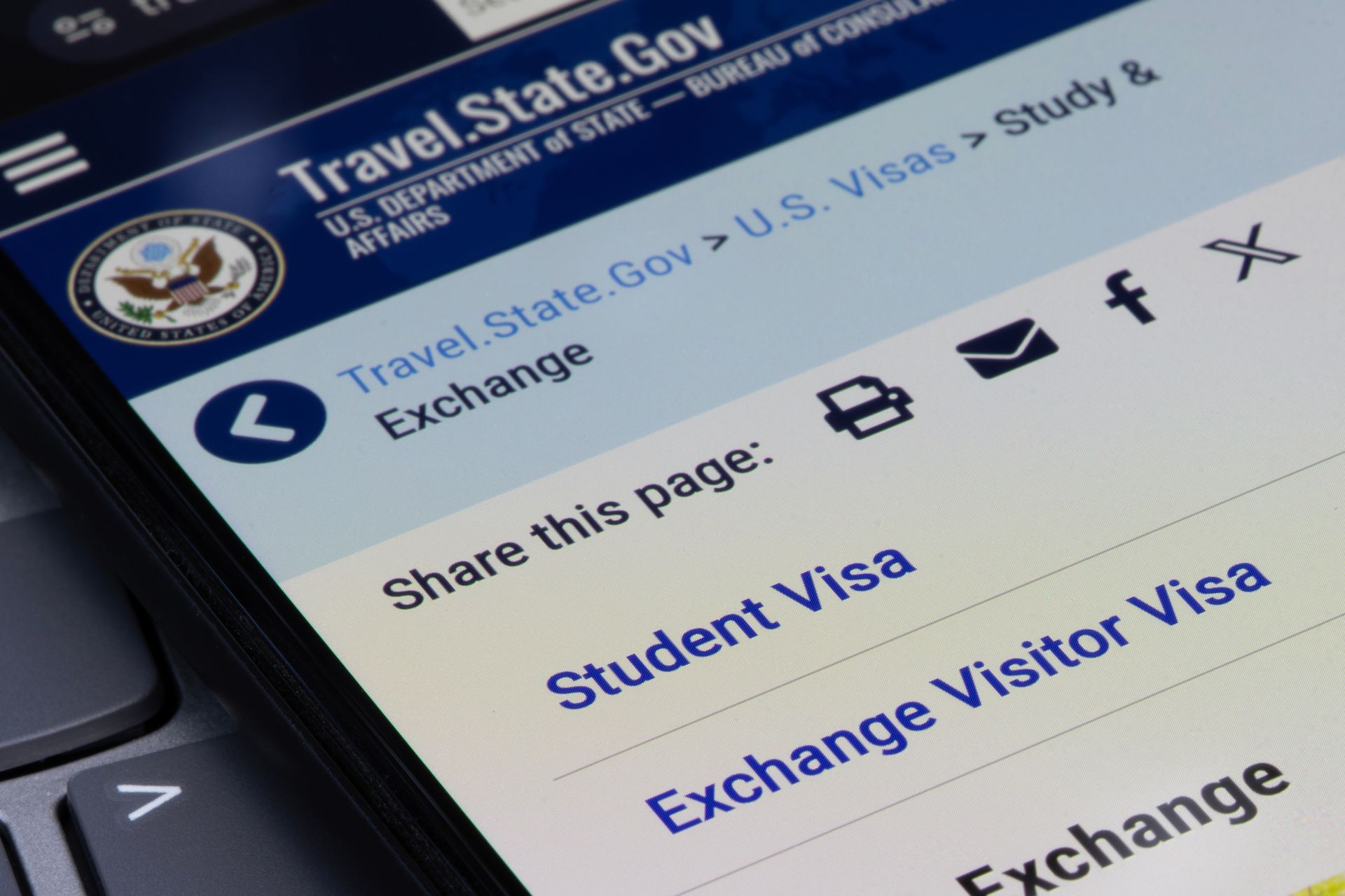 Close-up of Travel.State.Gov page showing student visa and exchange visitor visa links on a phone screen