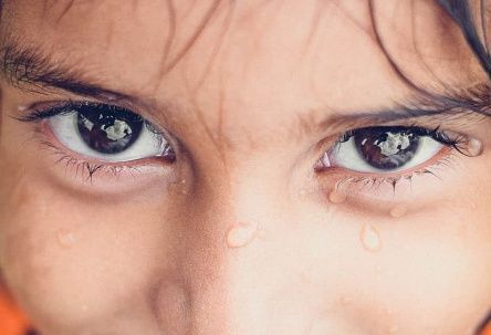 Close-up of a child’s eyes with tears on their cheeks