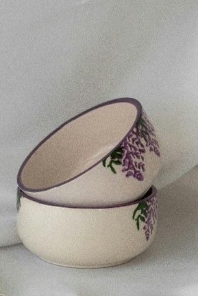 Two ceramic bowls, stacked. Off-white with purple rim and lavender floral design.