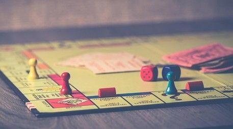 Monopoly board game with game pieces, dice, and money.